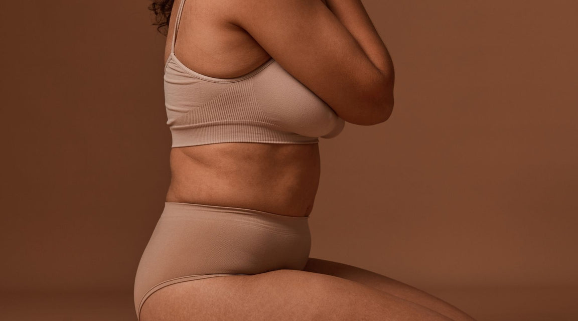 Person wearing a beige two-piece set against a brown background