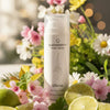 Skincare product with flowers and limes in the background. Quannessence Skincare, professional skincare, Holistic Beauty, Made in Canada, Naturally Sourced, Active ingredients, women-owned, Face, Cleanser, Cream, QRevive, Facial Cleansing Cream, white container with pump