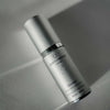 Skincare serum bottle labeled 'quannessence' on a neutral background. Quannessence Skincare, Infinity Collection, professional skincare, Holistic Beauty, Made in Canada, Naturally Sourced, Active ingredients, women-owned, Face, Serum, QSolstice, Solstice Redefining Serum, Silver packaging with silver lid and pump