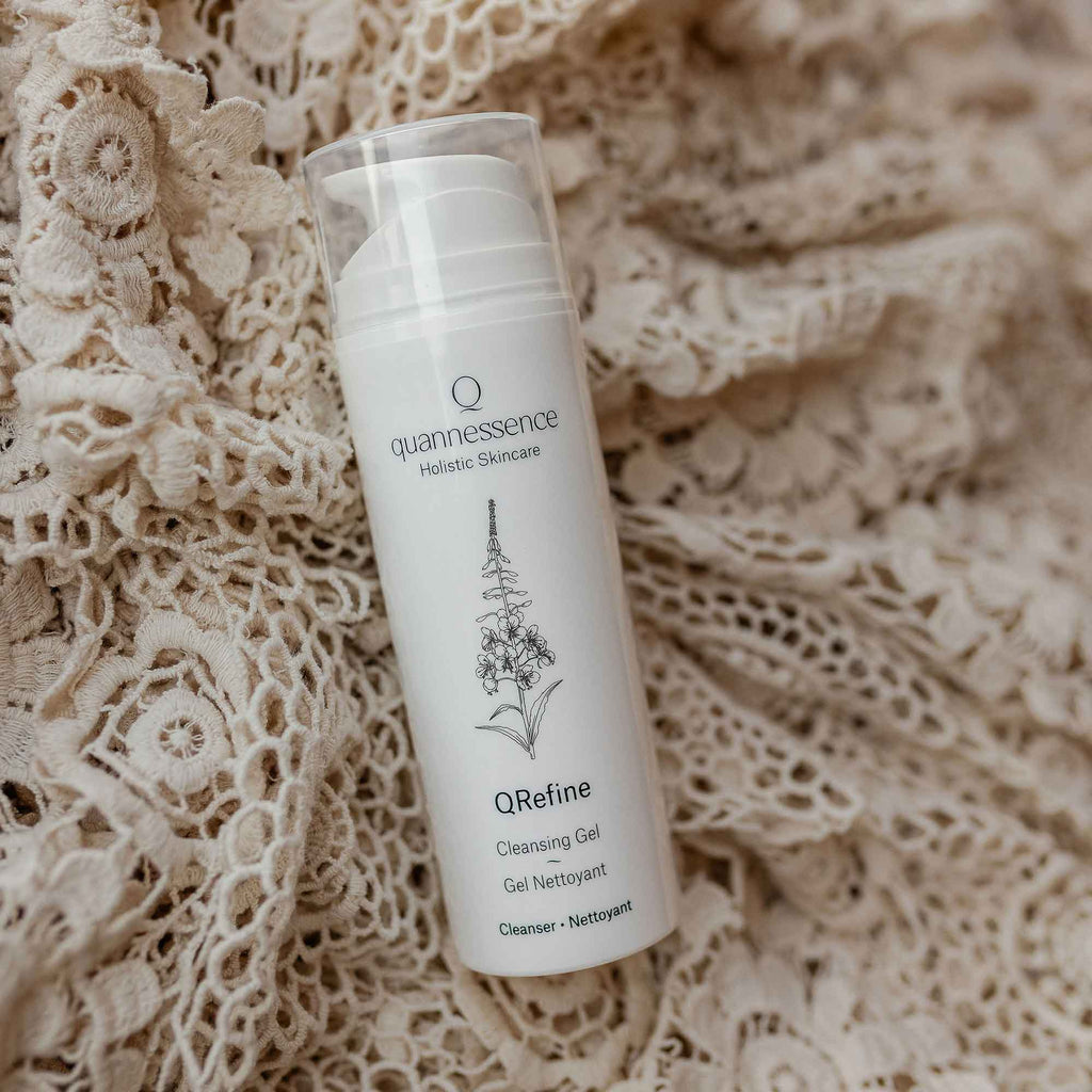 QRevive Cleansing Cream by Quannessence, Skincare bottle labeled 'quannessence' on a textured beige background. Quannessence QRevive Cleansing Cream bottle with floral elements on a light background. Quannessence Skincare, professional skincare, Holistic Beauty, Made in Canada, Naturally Sourced, Active ingredients, women-owned, Face, Cleanser, Cream, QRevive, Facial Cleansing Cream, white container with pump