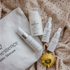Set of Quannessence skincare products on a textured fabric background. Quannessence Skincare, professional skincare, Holistic Beauty, Made in Canada, Naturally Sourced, Active ingredients, women-owned, Face, toner, Serum, Oil, QBeauty Sleep, 4-piece kit, white branded cotton travel pouch