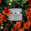 Quannessence skincare jar surrounded by vibrant orange and red flowers. Quannessence Skincare, professional skincare, Holistic Beauty, Made in Canada, Naturally Sourced, Active ingredients, women-owned, Face, Moisturizer, Lotion, Cream, QAlchemy, Alchemist Revitalizing Cream, white jar
