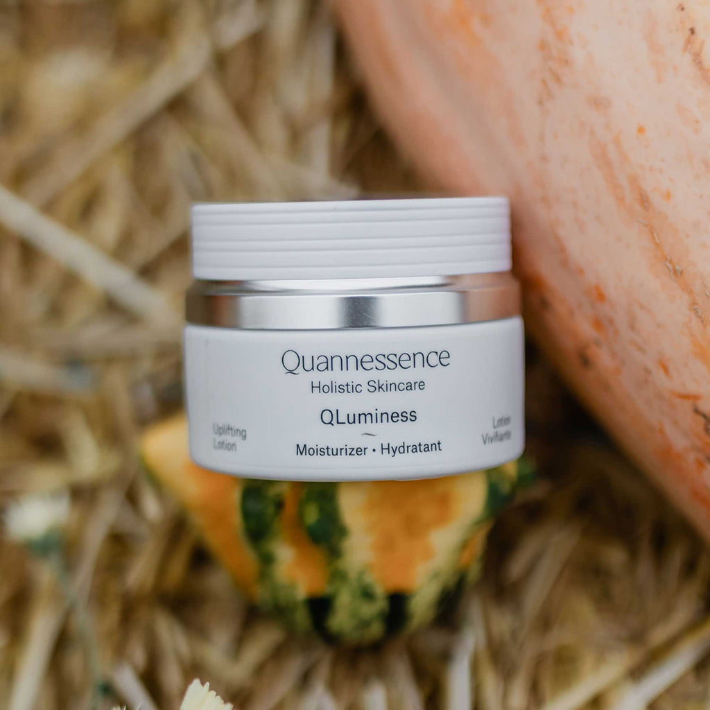 Quannessence skincare jar on a natural background. Quannessence Skincare, professional skincare, Holistic Beauty, Made in Canada, Naturally Sourced, Active ingredients, women-owned, Face, Moisturizer, Lotion, Cream, QLuminess, Luminess Face Lotion, white jar