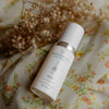 QGaia Enrichment Oil by Quannessence on floral background highlighting holistic skincare.