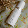 QGaia Enrichment Oil, QGaia skincare oil bottle on a floral background. Skincare bottle labeled 'quannessence' on a bed of orange flowers. Quannessence Skincare, professional skincare, Holistic Beauty, Made in Canada, Naturally Sourced, Active ingredients, women-owned, Face, Oil, All Natural, QGaia, Gaia Facial Enrichment Oil, white glass packaging with white lid & pump