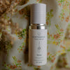 QGaia Enrichment Oil, Skincare bottle labeled 'quannessence' on a floral background. Skincare bottle labeled 'quannessence' on a bed of orange flowers. Quannessence Skincare, professional skincare, Holistic Beauty, Made in Canada, Naturally Sourced, Active ingredients, women-owned, Face, Oil, All Natural, QGaia, Gaia Facial Enrichment Oil, white glass packaging with white lid & pump
