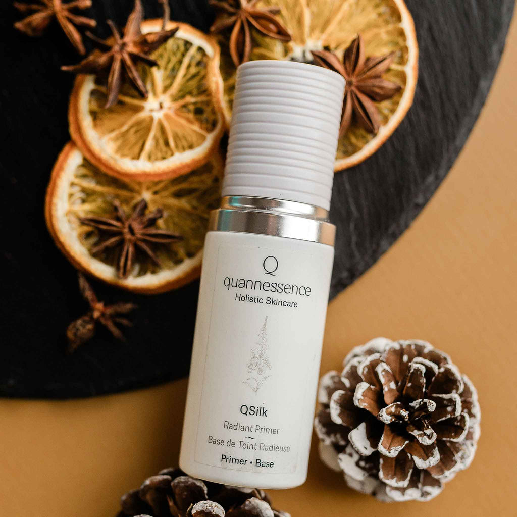 Quannessence Holistic Skincare bottle labelled 'quannessence' with decorative elements on a brown background