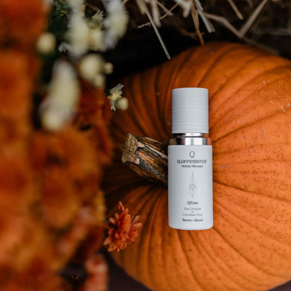 Skincare serum bottle with pump on a textured orange background. Quannessence Skincare, professional skincare, Holistic Beauty, Made in Canada, Naturally Sourced, Active ingredients, women-owned, Face, Serum, QFirm, IQ FIRMING GEL, white glass packaging with white lid & pump