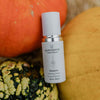Skincare serum bottle labeled 'quannessence' with pumpkins in the background. Quannessence Skincare, professional skincare, Holistic Beauty, Made in Canada, Naturally Sourced, Active ingredients, women-owned, Face, Serum, QHyaluron, Hyaluronic (PUR) Hydrating Serum, white glass packaging with white lid & pump