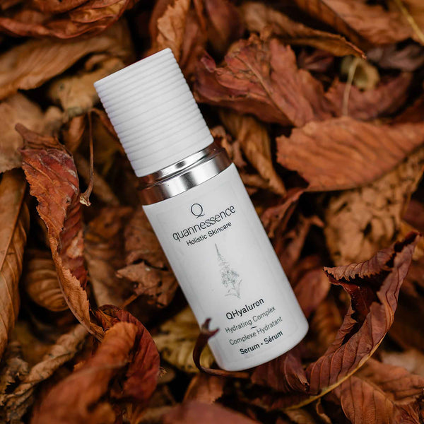 Skincare serum bottle labeled 'quanlessness' on a bed of dried leaves. Quannessence Skincare, professional skincare, Holistic Beauty, Made in Canada, Naturally Sourced, Active ingredients, women-owned, Face, Serum, QHYaluron, Hyaluronic (PUR) Hydrating Serum, white glass packaging with white lid & pump